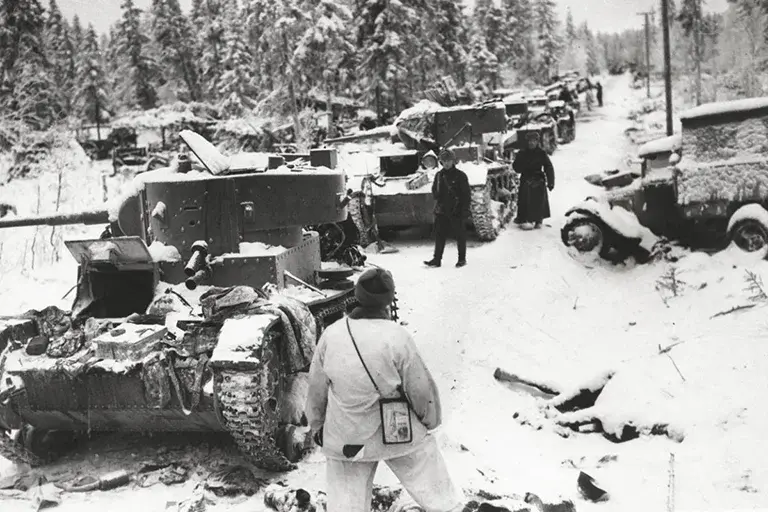 Finnish troops inspect abandoned Soviet T-26 and BT-5 tanks on the Raate Road on 8 January 1940.